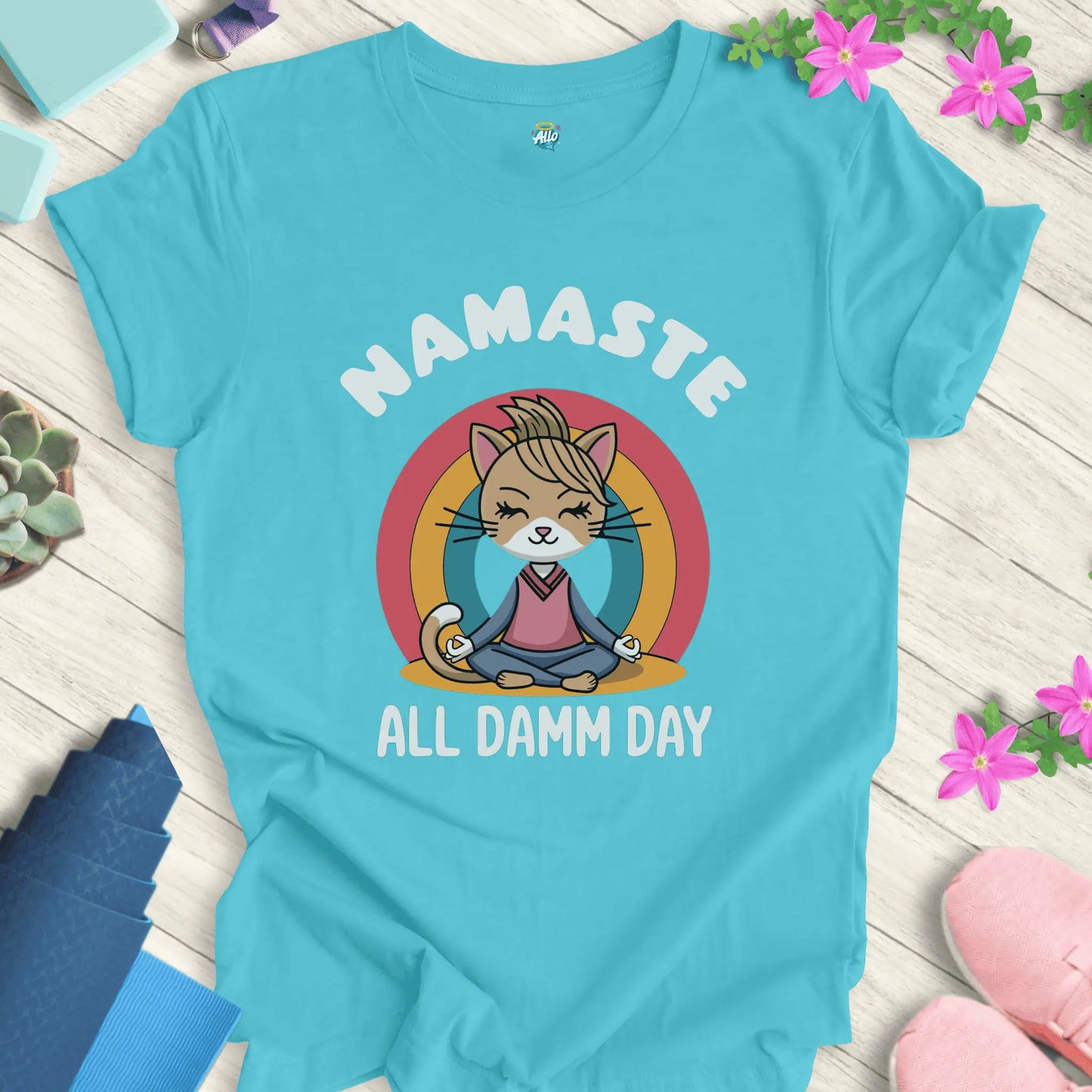 Turquoise yoga t-shirt with 'Namaste All Damm Day' design featuring a meditative cat by Halo Allo. Perfect for spiritual practice and casual wear.