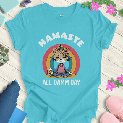 Turquoise yoga t-shirt with 'Namaste All Damm Day' design featuring a meditative cat by Halo Allo. Perfect for spiritual practice and casual wear.