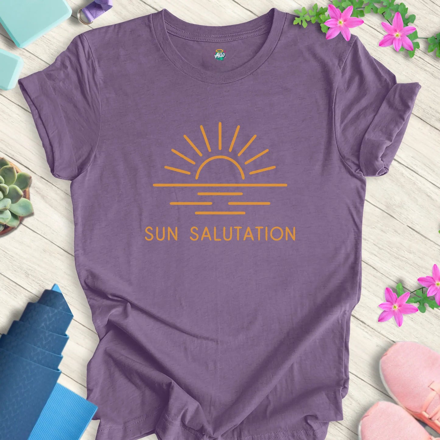 Heather Team Purple yoga t-shirt with 'Sun Salutation' design by Halo Allo, featuring a sunrise motif. Perfect for meditation enthusiasts.